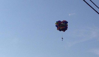 Uomo vola e atterra con un paracadute formato da 100 palloncini colorati