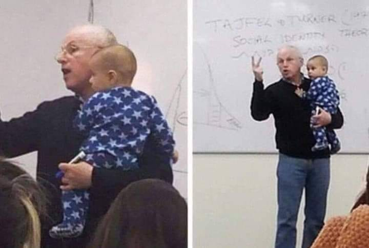 Professore universitario tiene in braccio il figlio di una studentessa mentre spiega
