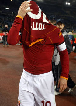 Francesco Totti cerca di nascondere con la maglia la delusione per l'eliminazione della sua Roma